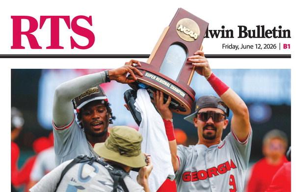 Georgia third baseman Tre Phelps (left) and shortstop Kolby Branch hoist the Athens Super Regional trophy after the Bulldogs clinched a trip to the College World Series with an 11-9 victory over Mississippi State in Game 2.