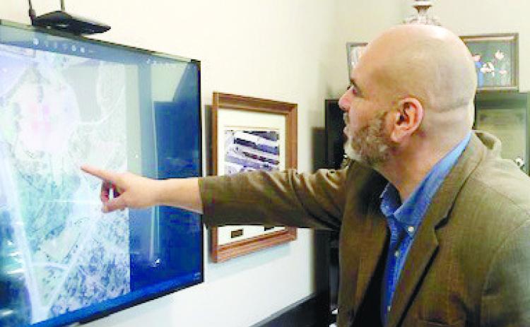 County Manager Carlos Tobar points out the holes on the disc golf course. GREENBERRY MOORE/Staff