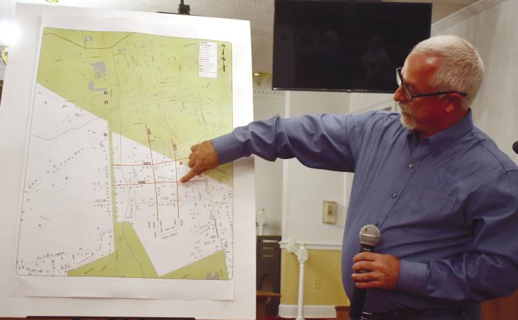 Engineer Shon Hampton explains the one-way streets to the audience using Coombs Avenue SE as an example on the map. BAILEY BALLARD/Staff