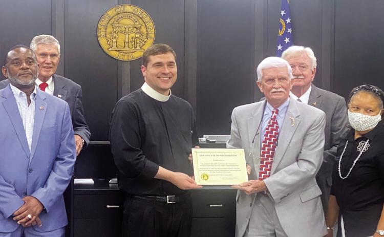 The Board of Commissioners presented newly appointed Father Bryan Kuhr of Sacred Heart Catholic Church with a plaque recognizing the church’s 150th anniversary. HANNAH MITCHELL/Staff