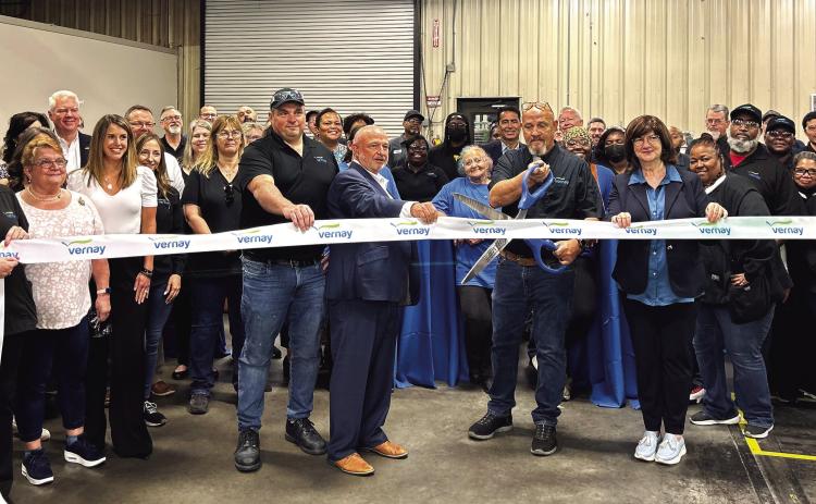 Milledgeville Plant Manager Doug Cumpston does the honors of cutting the ribbon for the re-opening. Local and corporate employees of Vernay and community members smile with pride at the ceremony. ANSLEY KATE ALLEN/Staff