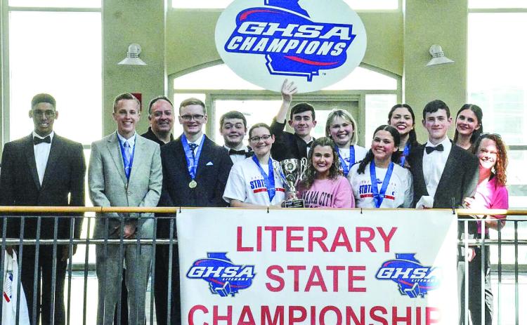 The Georgia Military College Preparatory School literary team shows off the state championship trophy and celebrates their victory with coaches Mark Weaver and Jenny Morris. COURTESY OF GMC