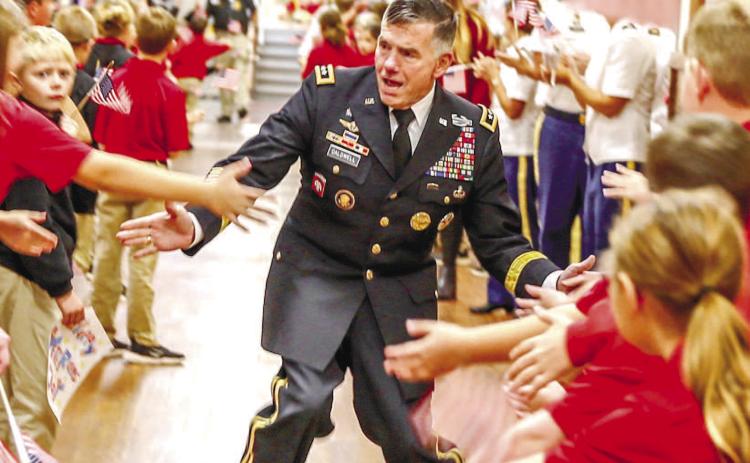 Students cheer and applaud GMC President William B. Caldwell IV as he walks-thru the elementary hallway. CONTRIBUTED