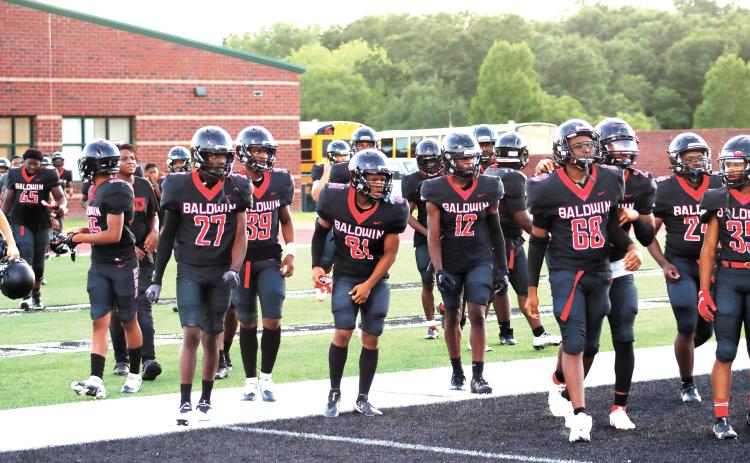 Braves run out of the locker room ready for the second half of their fall scrimmage. BRENDAN KOERNER/Staff