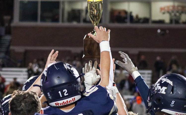 Several Trojans' players hold up the trophy following the post-game ceremonies.