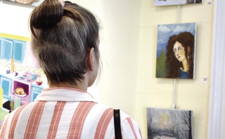 Audrey Crumbley admires Molly Fox’s paintings. BAILEY BALLARD/Staff