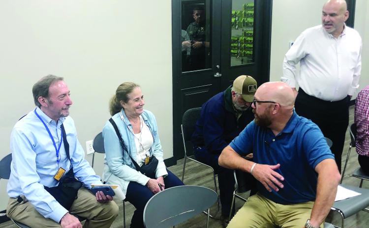 Ballot monitors Jon and Carol Schoenhorn (l-r), county commissioner-elect Scott Little and County Manager Carlos Tobar (standing) were among those at election headquarters Tuesday night. GREENBERRY MOORE/Staff