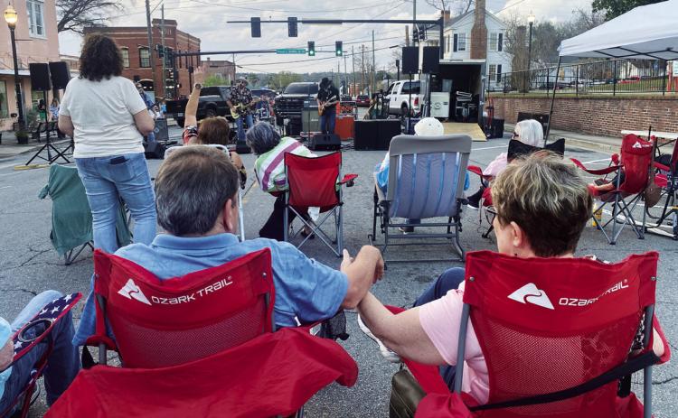 First Friday music fans enjoy a live performance March 6, on the blocked-off streets of downtown Milledgeville. PHOTOS BY VICTORIA ANADENKO/Staff