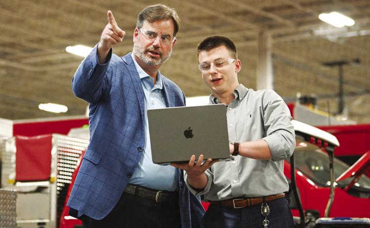Fouts Bros Inc. President and CEO Scott Edens, left, with Fouts employee and GCSU alumnus Grant Motley on the factory floor. Fouts Bros is investing in enterprise level AI solutions and Edens plans to hire interns from the new Master of Science in AI Strategy program. CONTRIBUTED/Anna Gay Leavitt