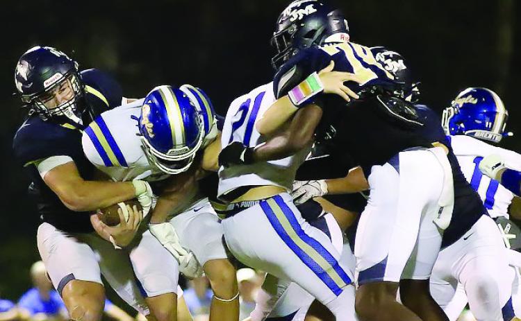 JMA’s Asa Wall (far left) tackles a Brentwood ball carrier last Friday at home in Milledgeville. TREY NORRIS/Staff