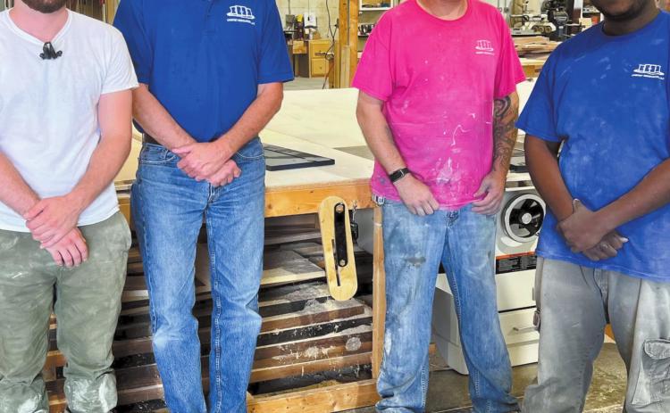 Randy Smith (blue shirt in middle) takes a photo with his employees at Cabinet Resources as they work on various renovation projects.