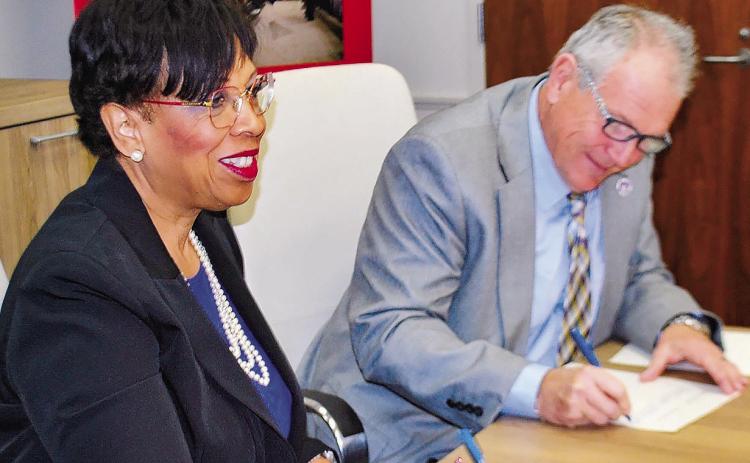 Superintendent Dr. Noris Price (left) signs an agreement with President of Middle Georgia State University Dr. Christopher Blake. CONTRIBUTED