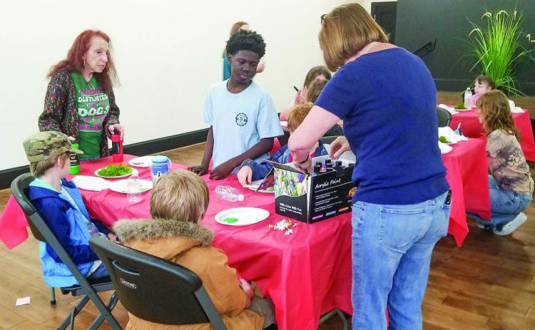 Students prepare to make fairy houses with teacher Janice Westfall (right) and volunteer Cookie Noel inside Allen’s Market. CONTRIBUTED