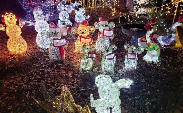 A collection of animals and snowmen have gathered to sing carols to passersby.