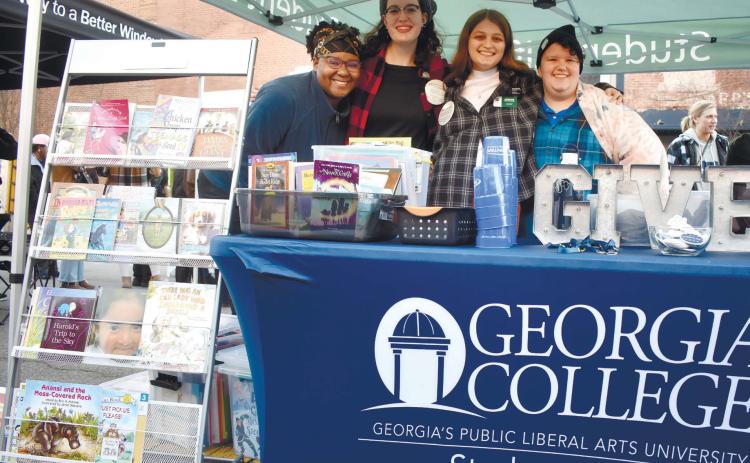 Georgia College &amp; State University students with the Student Life organization and the GIVE Center give out free books to attendees.
