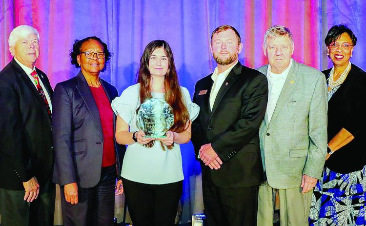 Associate editor of The Baldwin Bulletin Bailey McCully (center) stands with the Baldwin County Board of Education members and Superintendent Dr. Noris Price (right) after accepting the Beacon Award. ERIC JONES/Contributed