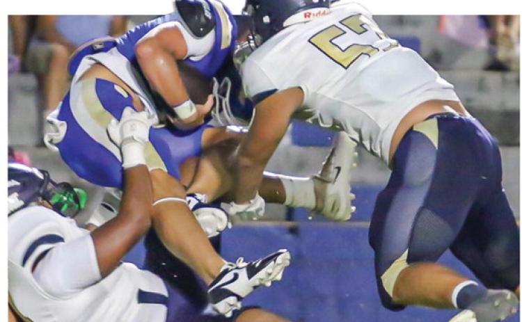 JMA’s Kellen Eady (57) and the Trojans defense swarm the Eagles starting quarterback in last Friday’s 31-7 win. TREY NORRIS/Staff