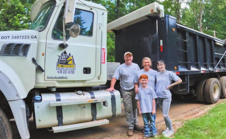 John McIntosh with his family in front of one of their trucks and other equipment used for JME Excavation. CONTRIBUTED BY JESSICA MCINTOSH