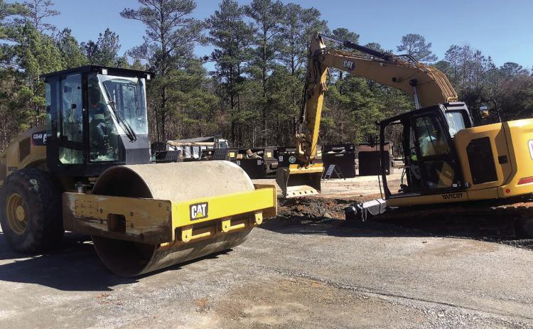 Travis Grable packs the new crusher run while Phillip Harris digs out existing asphalt. GREENBERRY MOORE/Staff