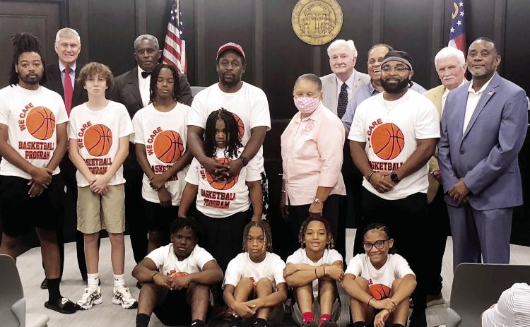 James Lunsford (L-R: second from last in the back row) poses with commissioners and We Care program participants at the Tuesday meeting after offering thanks to the commissioners for supporting the program.