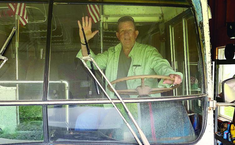 T.M. Brown sits in the driver’s seat of Fred and Kay Wallace’s bus that serves as the inspiration to the next installment in his Shiloh mystery series. CONTRIBUTED