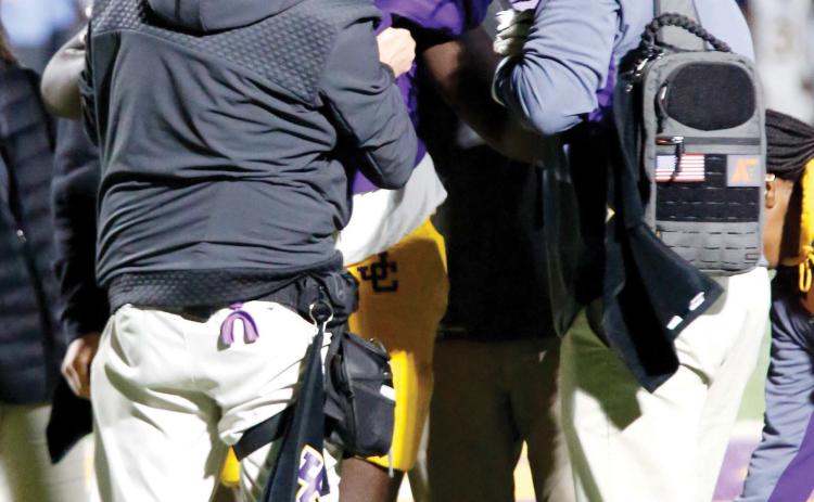 Garrett Law and first-year athletic training graduate student Reeder Chambers (right) assist an injured Jones County football player. HUDSON TAYLOR/Staff