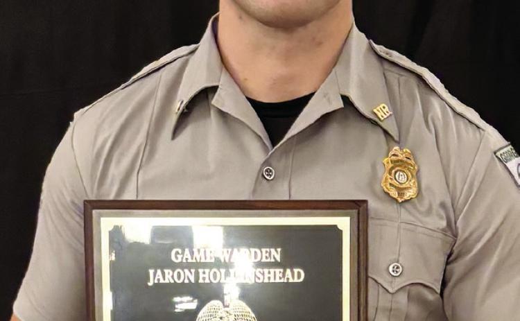Game Warden Jaron Hollinshead poses with the 2024 Georgia Level Torch Award. CONTRIBUTED