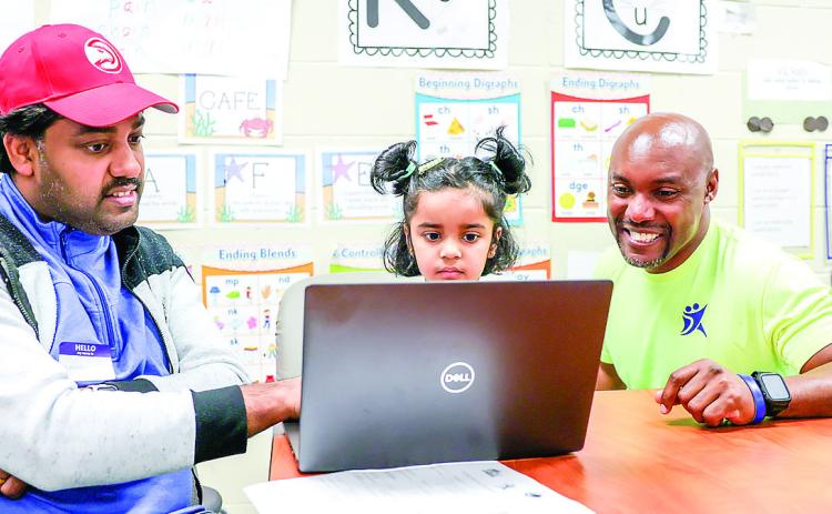 Richard Hicks (right) engages with a family during a Brumby Elementary Family Workshop. COURTESY OF GCSU