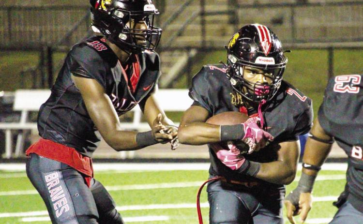 Baldwin Braves quarterback LJ Pounds (left) completes a handoff to running back Sadur Salahuddin in a game played earlier this season. TREY NORRIS/Staff