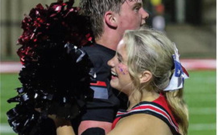 Evan Stasney receives a hug from a Bulldogs cheerleader after GMCP’s win over Glenn Hills. TREY NORRIS/Staff