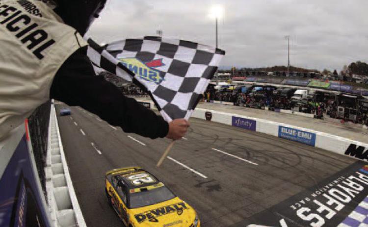 Christopher Bell, driver of the No. 20 DeWalt Toyota, takes the checkered flag to win the Cup Series Xfinity 500 at Martinsville Speedway Sunday. (Mike Mulholland/Getty Images)