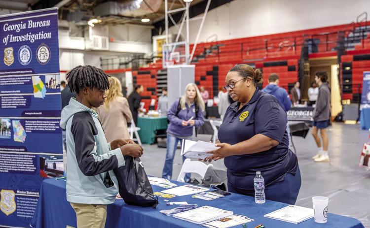A student speaks with a representative from the Georgia Bureau of Investigations about potential future jobs. CONTRIBUTED