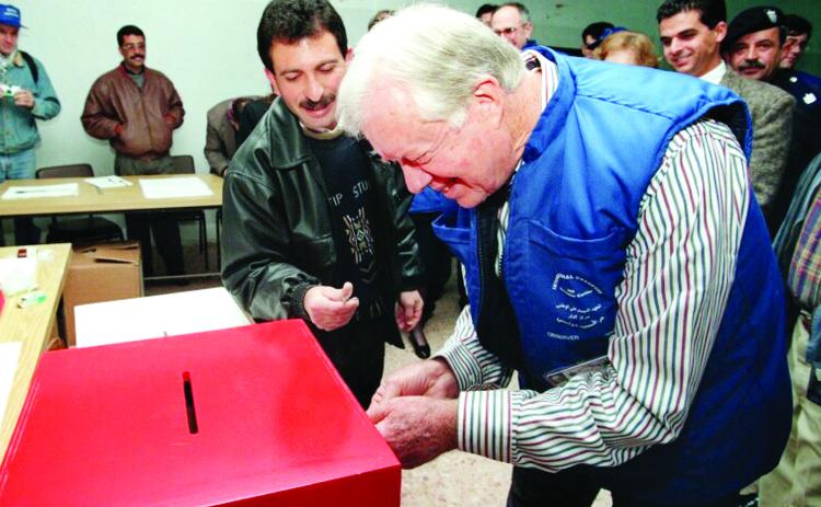 Former President Jimmy Carter votes at a ballot box. He monitored elections in more than 100 countries. CONTRIBUTED