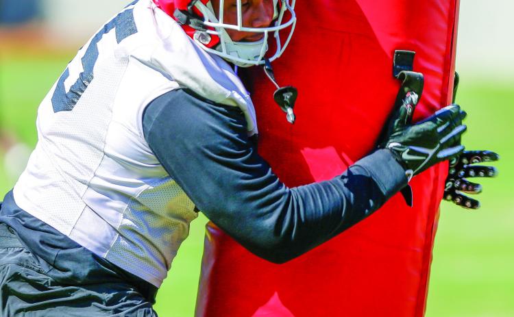 Georgia defensive lineman Nnamdi Ogboko hits a practice dummy at full speed during a drill at practice on March 19.