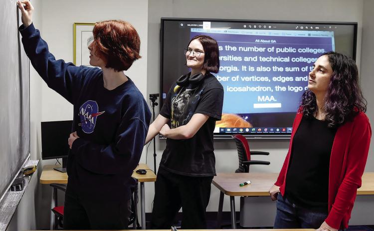 Mathematics majors Caroline Hegwood (left) and Monica Lichtenwalner practice for the Math Jeopardy competition with their advisor, Dr. Rachel Epstein (far right). COURTESY OF GCSU