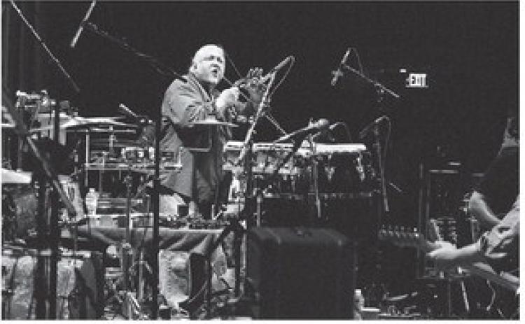 GCSU professor Rob Sumowski works the tambourine as a member of Brantley Cobb’s band during a performance Dec. 5 at the Ryman Auditorium in Nashville. COURTESY OF GCSU