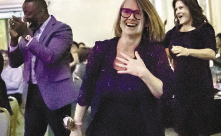 Susan Curtis walks toward the stage with a mix of joy and shock over the announcement. CONTRIBUTED BY ERIC JONES