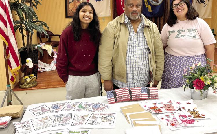 GCSU student Sunita Oliver, veteran David Wise, and student Alexis Keeney pose in front of the cards created during the Martin Luther King Jr. Service Day. CONTRUBUTED
