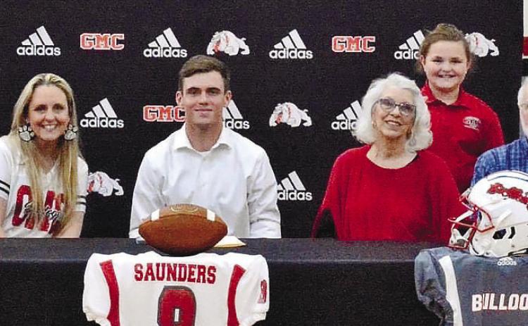 Saunders sits with family after he signed with GMC last week. CONTRIBUTED