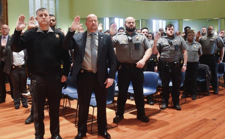 Sixty-two Baldwin County Sheriff’s Office’s officers of various positions gathered Jan. 2 in the legislative chamber in Georgia Military College’s (GMC) Old Capital Building to be sworn in. Following all officers being sworn in, Sheriff Bill Massee (not pictured) announced that Major Scott Deason (left front row) will be promoted to chief deputy. BAILEY MCCULLY/Staff