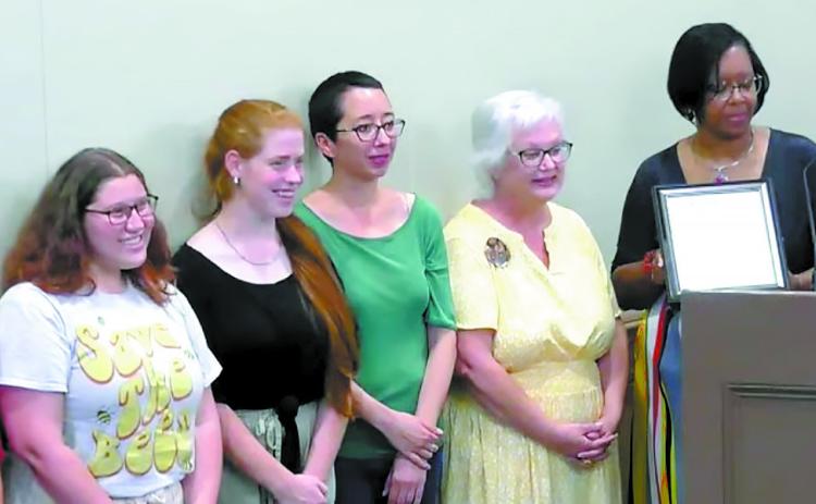 Gordon and her students stand with Mayor Mary Parham-Copelan as they listen to the proclamation for Women’s Equality Day being read. SCREENSHOT