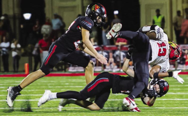 Sophomore J.D. Allen (on ground) upends a Bucs ball carrier last Friday at Davenport Field. TREY NORRIS/Staff