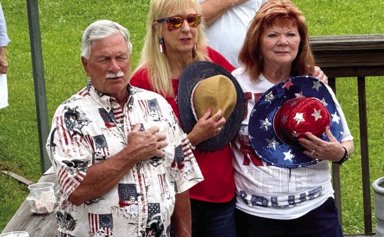Local residents arrived by boat and car to Duke’s Lounge and Dawg House in Milledgeville for Memorial Day ceremonies, including the Pledge of Allegiance, delivered by Georgia Bulldogs broadcaster Jeff Dantzler. IAN TOCHER/Staff