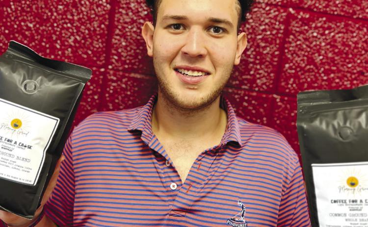 GCSU student Justin Harned of Pi Kapp holds LEC’s Coffee with a Cause coffee beans. CONTRIBUTED
