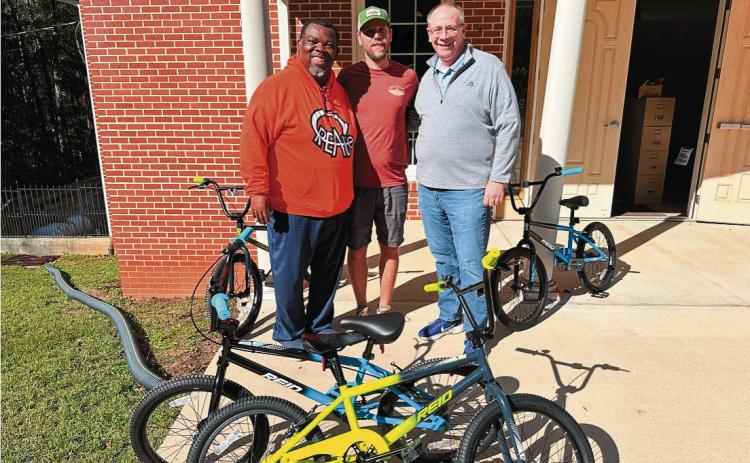 The Center for Recreation Education Arts Technology and Enterprise Inc. (CREATE) Director Gregory Barnes, Oconee Outfitters owner Adam Heagy, and Community Baptist Church Pastor Chip Reeves presented 46 bikes to the Baldwin County Board of Education. CONTRIBUTED