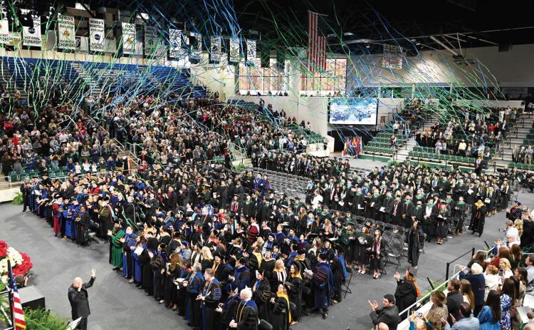 Georgia College &amp; State University graduates celebrate by releasing GCSU-colored streamers above the crowd after their commencement ceremony. COURTESY OF GCSU