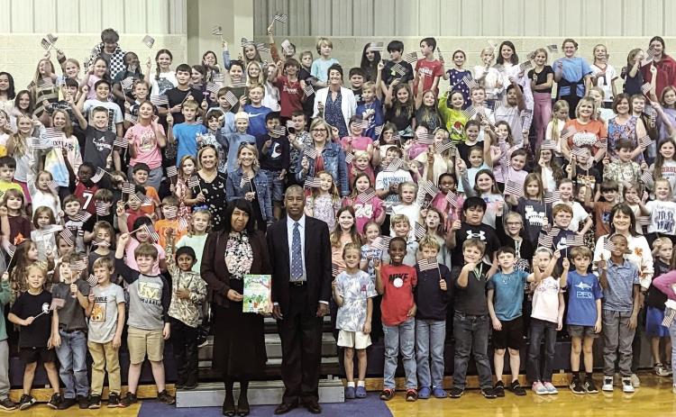 Dr. and Mrs. Carson, along with lower school students and faculty, pose in the gymnasium with their new books. CONTRIBUTED