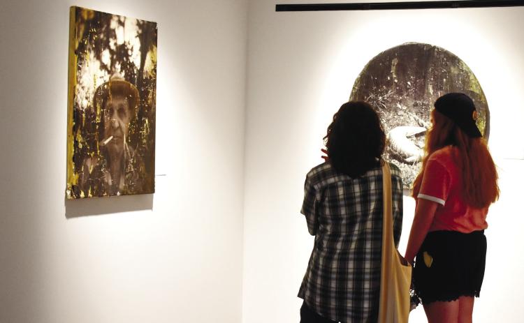 Students look at photography pieces submitted by Seth Cook.