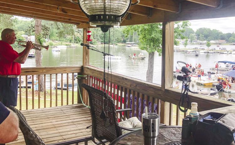 People arrive by land and by lake to listen to Ret. Col. Larry McClendon play “Taps” May 29 at Lake Sinclair. GREENBERRY MOORE/Staff