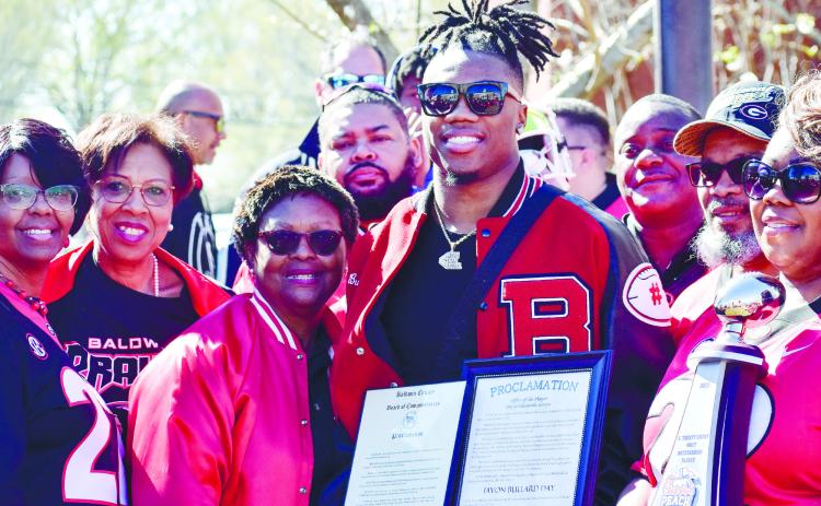 Javon Bullard poses with family, friends, and Milledgeville Mayor Mary Parham-Copelan (far left) while holding the proclamation for Javon Bullard Day. SEE FULL COVERAGE >> PAGE C1 NICHOLAS RYAN/Staff